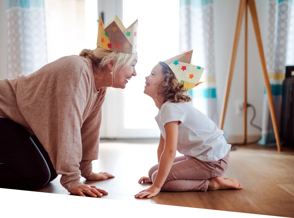 there is a woman and a little girl wearing paper crowns